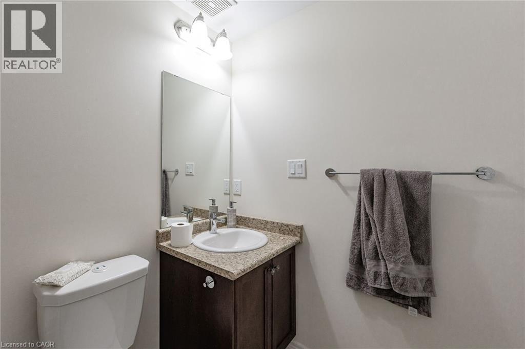 Bathroom featuring a corner vanity with a granite countertop, undermount sink, and a dark wood cabinet - 2453 Village Common, Oakville, ON - Indoor Photo Showing Bathroom