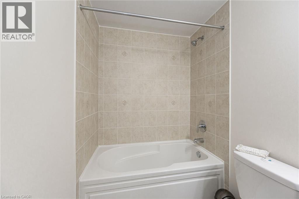 Bathroom with a bathtub and tiled shower surround, featuring a shower head and faucet - 2453 Village Common, Oakville, ON - Indoor Photo Showing Bathroom