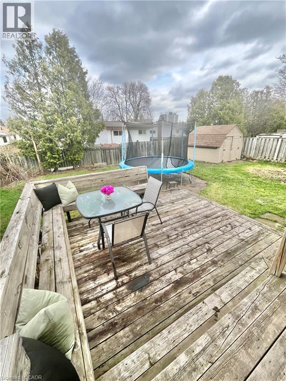 The property includes a wooden deck with integrated bench seating, a grassy yard, and a storage shed - 241 Thorner Drive, Hamilton, ON - Outdoor With Deck Patio Veranda