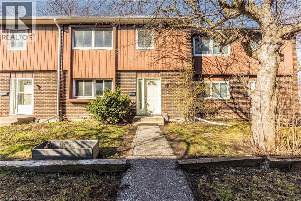 The property features a brick and siding exterior with multiple windows - 121 University Avenue E Unit# 102, Waterloo, ON - Outdoor
