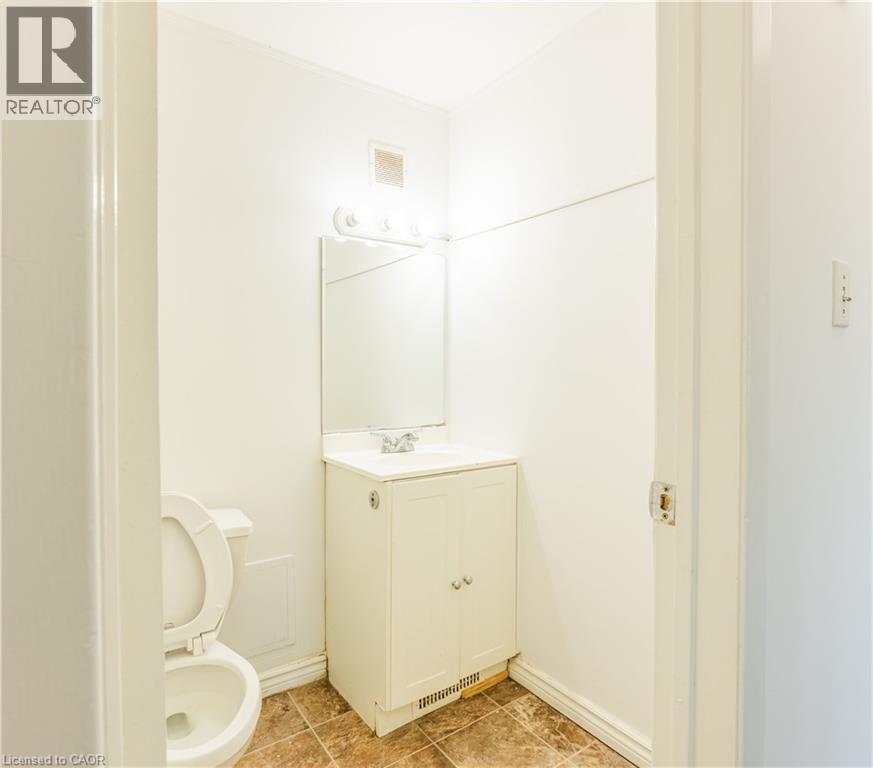 The bathroom features a vanity with a sink, a mirror, and a toilet - 121 University Avenue E Unit# 102, Waterloo, ON - Indoor Photo Showing Bathroom