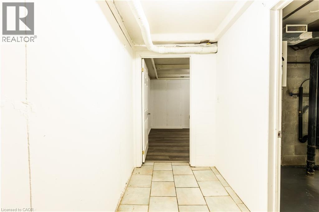 Hallway featuring tiled flooring and a white painted wall - 121 University Avenue E Unit# 102, Waterloo, ON - Indoor Photo Showing Other Room