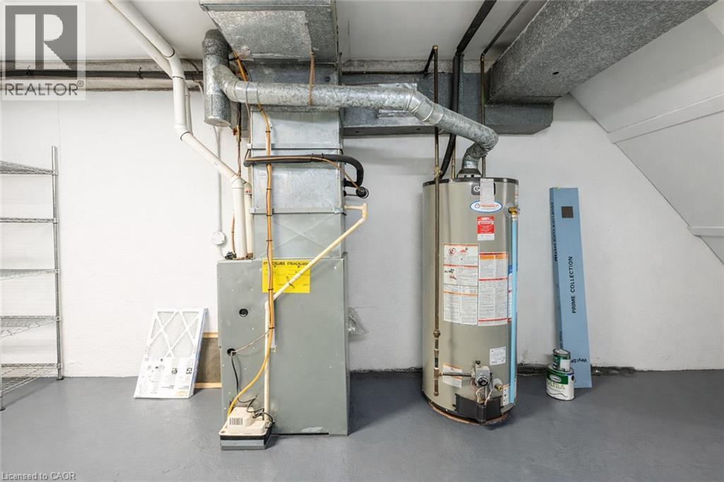The property includes a water heater and furnace, along with visible ductwork and piping - 121 University Avenue E Unit# 102, Waterloo, ON - Indoor Photo Showing Basement