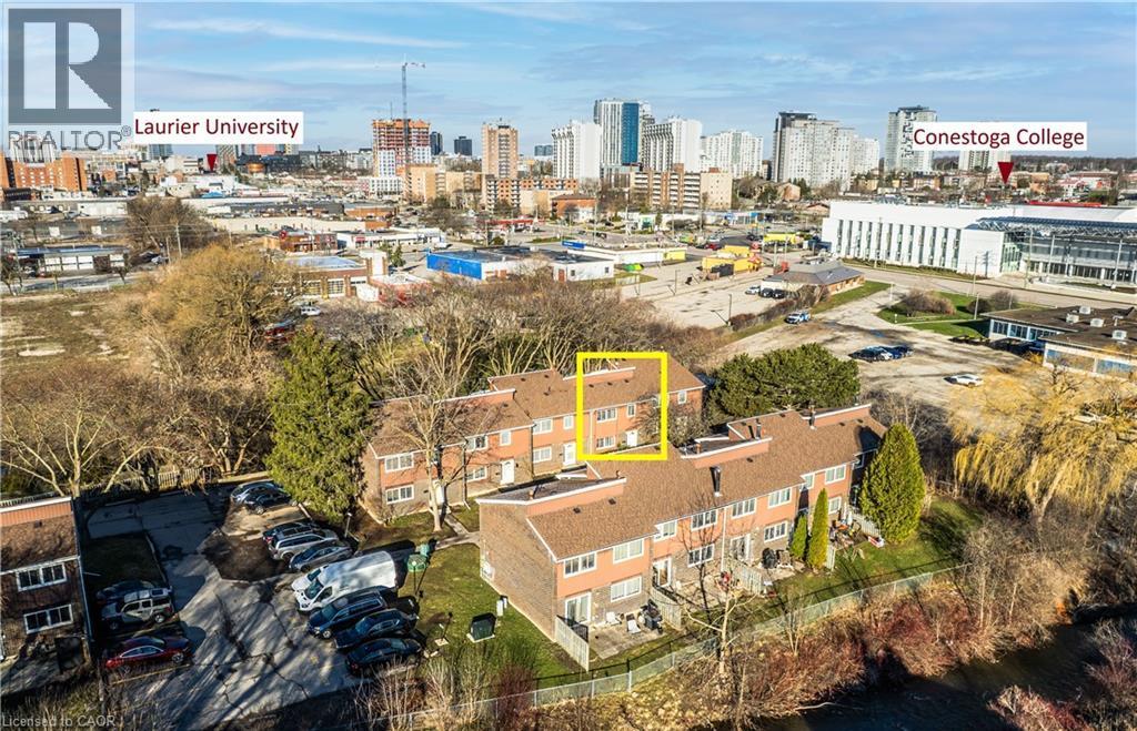 Aerial view of the property, showcasing its brick exterior and proximity to urban amenities - 121 University Avenue E Unit# 102, Waterloo, ON - Outdoor With View