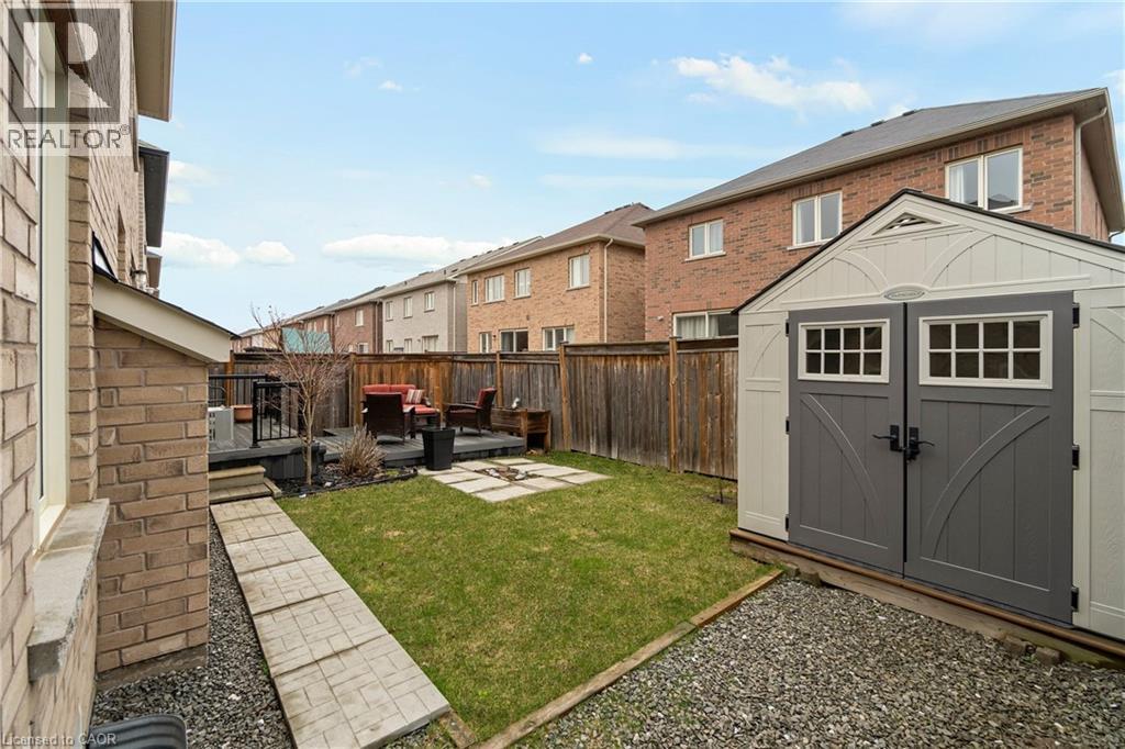 The property features a backyard with a lawn area, a wooden deck, and a storage shed - 4 Macbean Crescent, Waterdown, ON - Outdoor