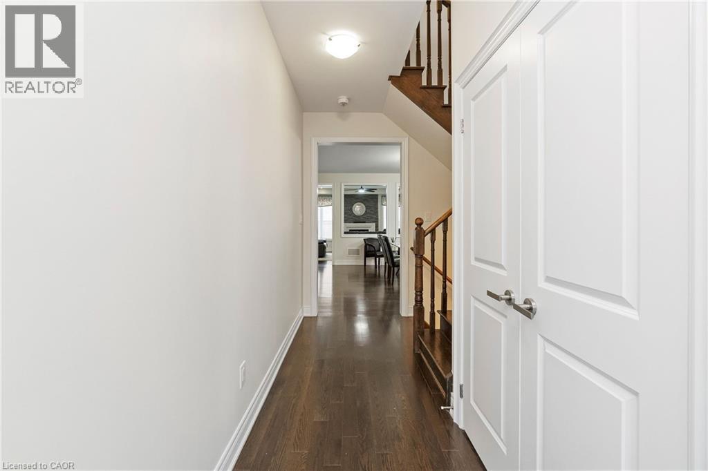 Hallway featuring hardwood floors, white trim, and a staircase with wooden handrails - 4 Macbean Crescent, Waterdown, ON - Indoor Photo Showing Other Room