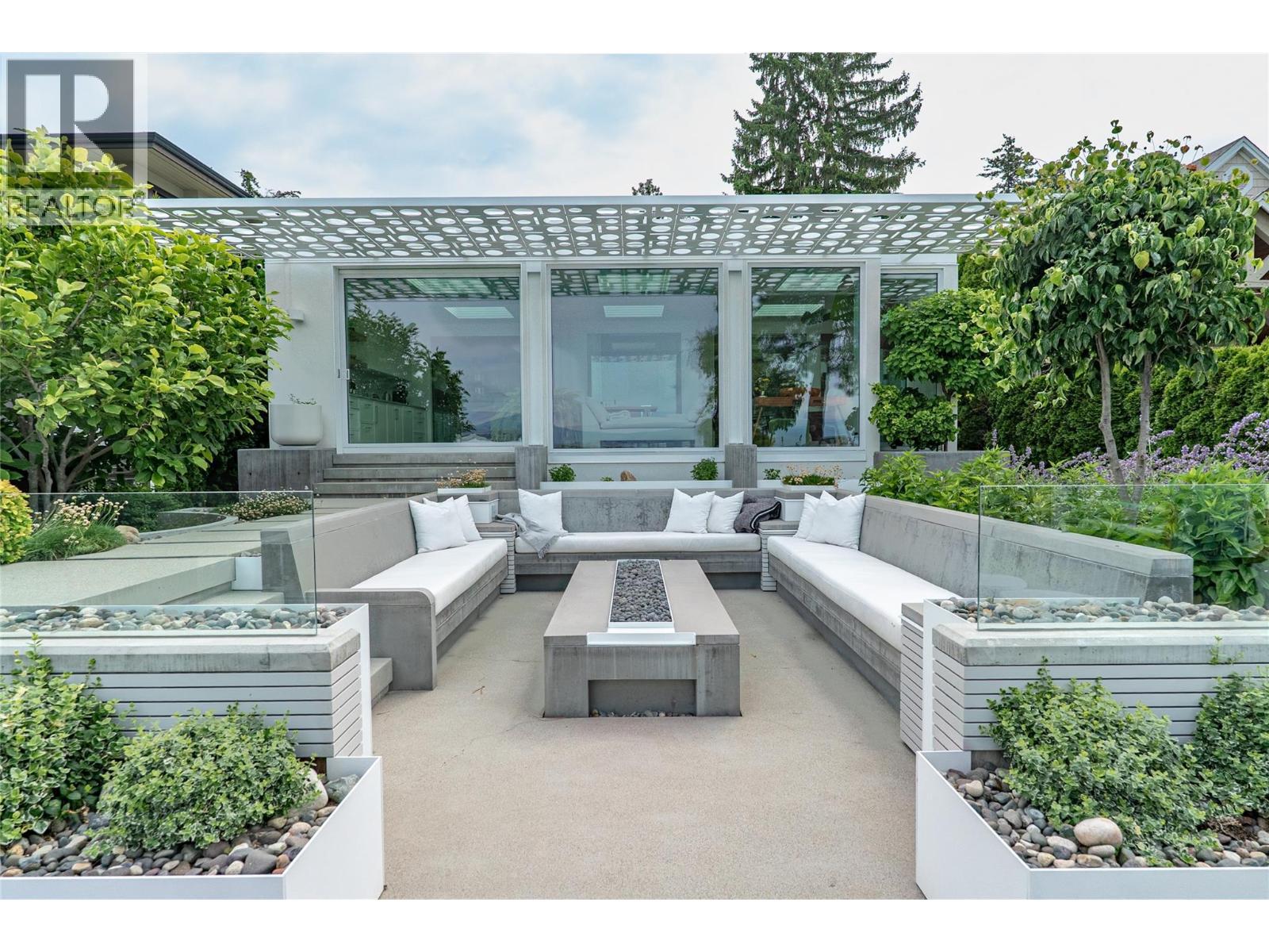 A backyard oasis with a 14 person seated gas fire pit with built in speakers and a wind dam - 4110 Lakeshore Road, Kelowna, BC - Outdoor