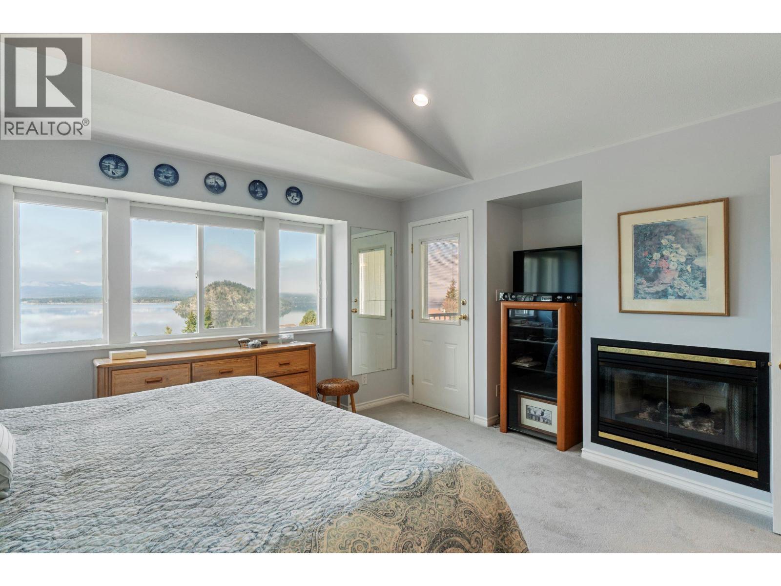3471 Mcbride Road, Blind Bay, BC - Indoor Photo Showing Bedroom With Fireplace