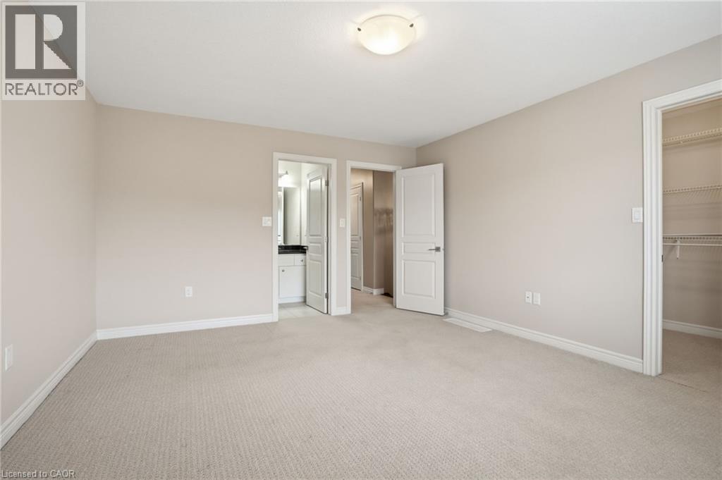 Master bedroom featuring a walk in closet and light colored carpet - 91 Chamomile Drive, Hamilton, ON - Indoor Photo Showing Other Room