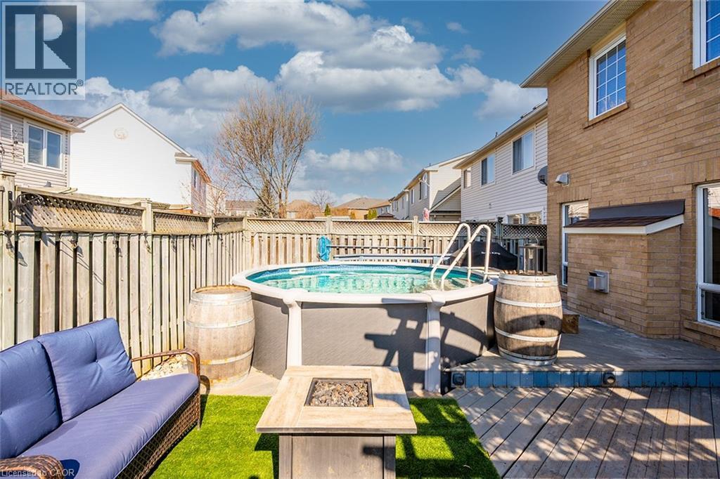 View of pool featuring a fenced backyard, a deck, an outdoor living space with a fire pit, and a residential view - 599 Caverhill Crescent, Milton, ON - Outdoor With Above Ground Pool