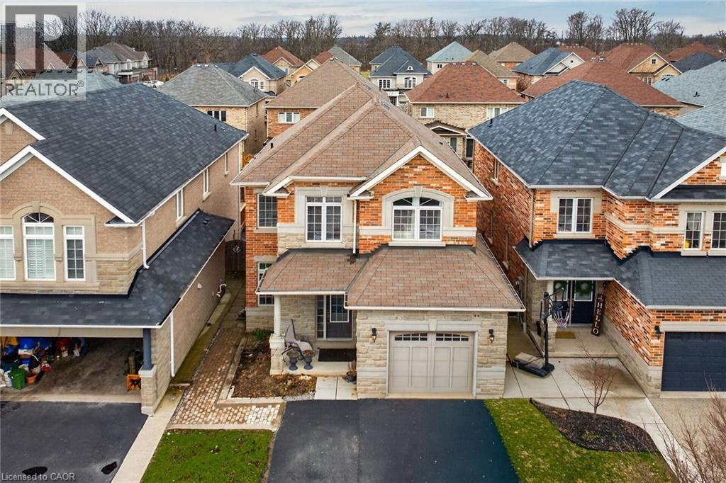 Exterior view of the property featuring a paved driveway, an attached garage, and a covered front entrance - 44 Matteo Trail, Hamilton, ON - Outdoor With Facade
