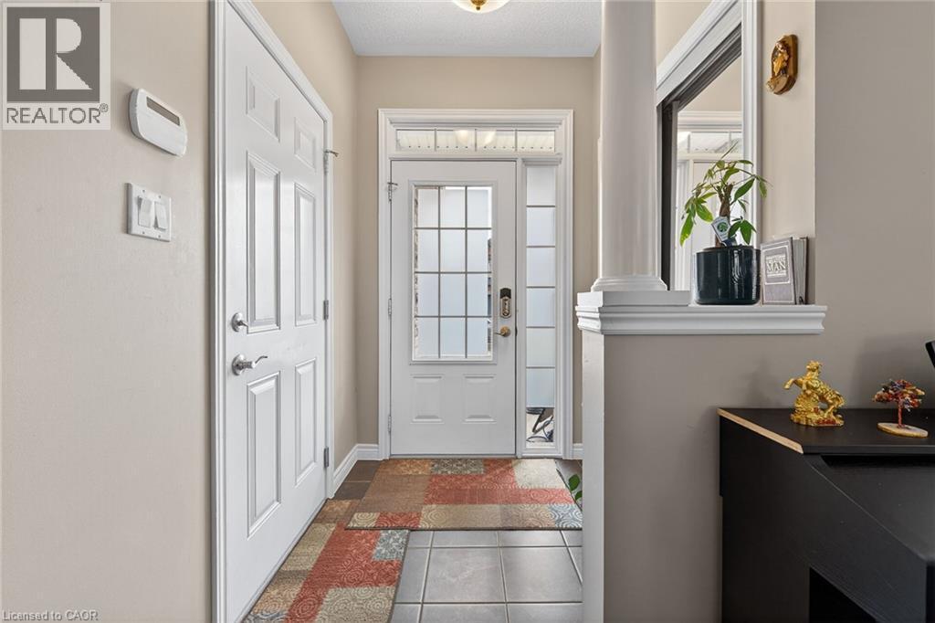 Welcoming entryway featuring a white paneled door, a glass-paned entry door with sidelights, and light-toned walls - 44 Matteo Trail, Hamilton, ON - Indoor Photo Showing Other Room