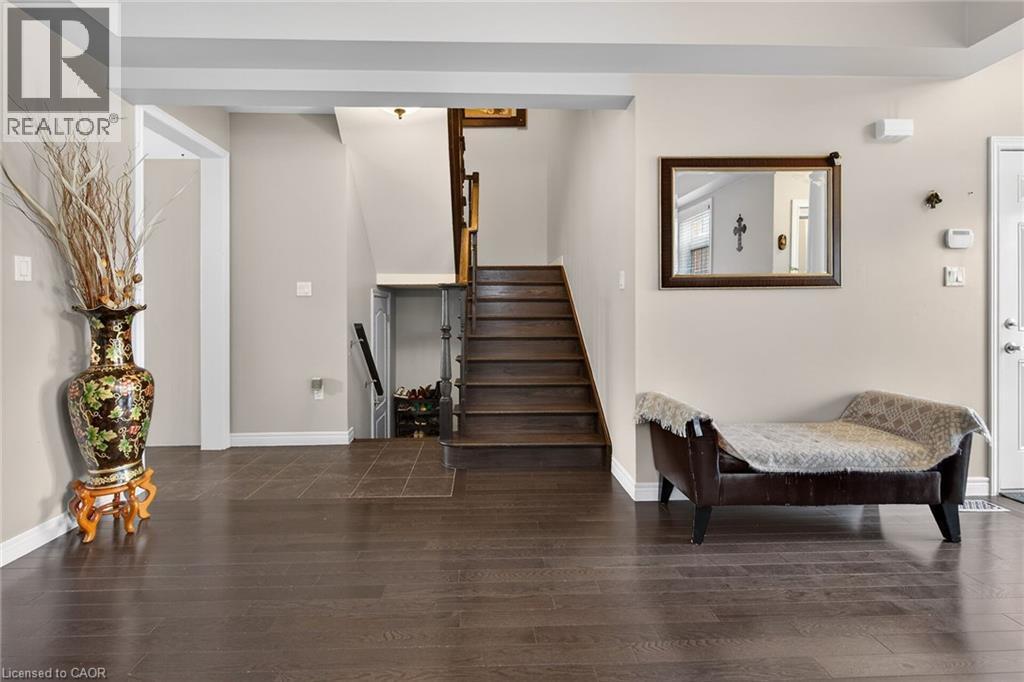 The property features dark wood flooring and a staircase with wooden treads - 44 Matteo Trail, Hamilton, ON - Indoor