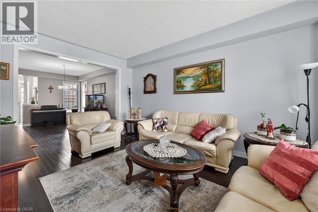 The inviting living area features dark wood flooring and light-colored walls, providing a bright and spacious feel - 44 Matteo Trail, Hamilton, ON - Indoor Photo Showing Living Room