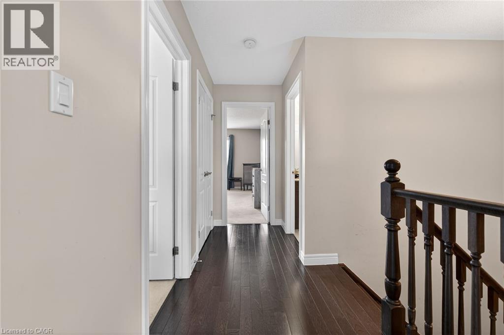 This hallway features dark hardwood floors and light-colored walls - 44 Matteo Trail, Hamilton, ON - Indoor Photo Showing Other Room
