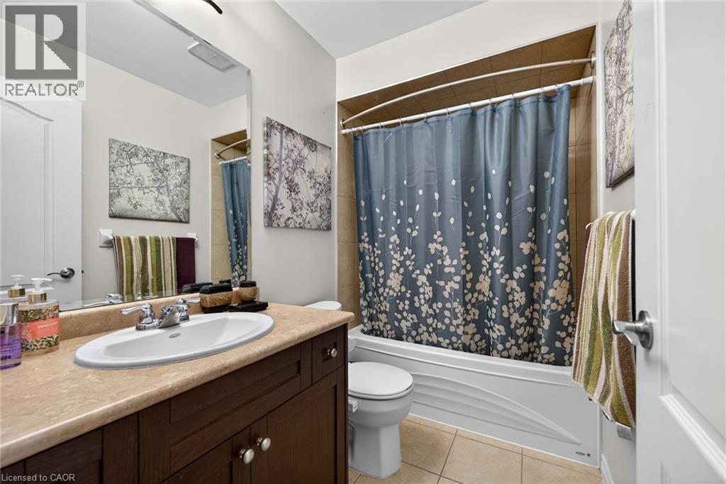 The bathroom features a vanity with a countertop and an integrated sink, a mirror, and a shower-tub combination - 44 Matteo Trail, Hamilton, ON - Indoor Photo Showing Bathroom