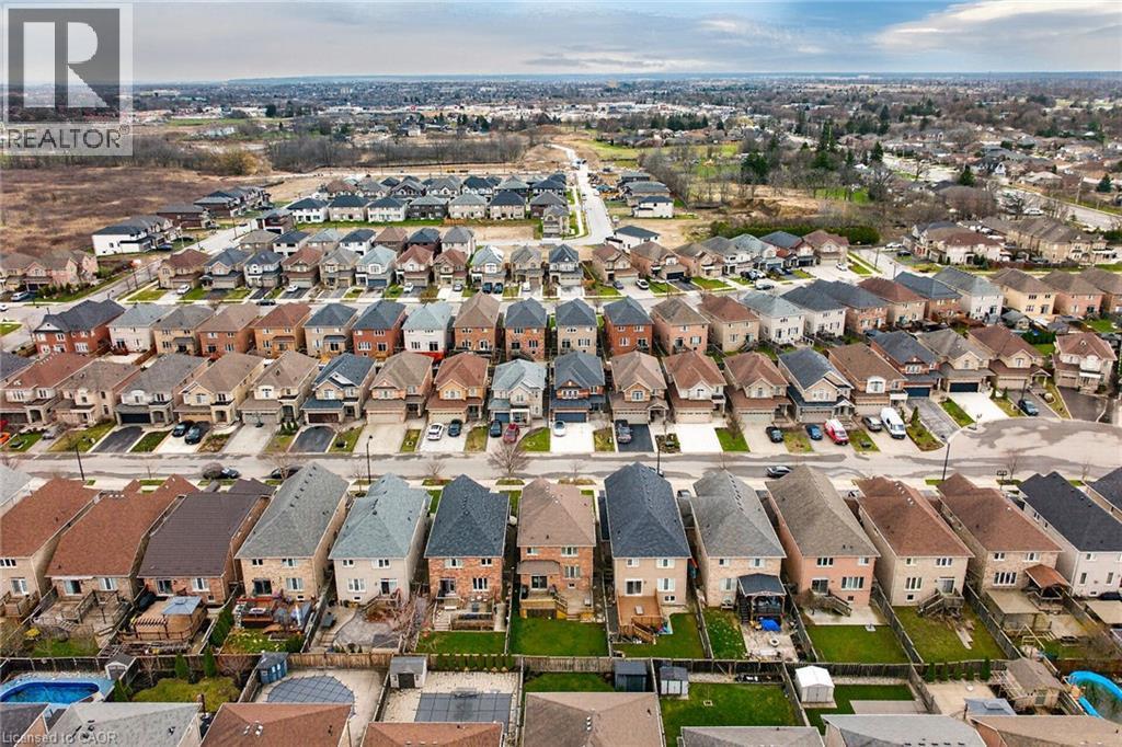 Aerial view of a residential neighbourhood featuring a variety of properties with sloped roofs and private driveways - 44 Matteo Trail, Hamilton, ON - Outdoor With View