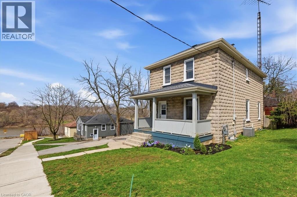 The property features a stone facade and a front porch - 12 Todd Street, Cambridge, ON - Outdoor
