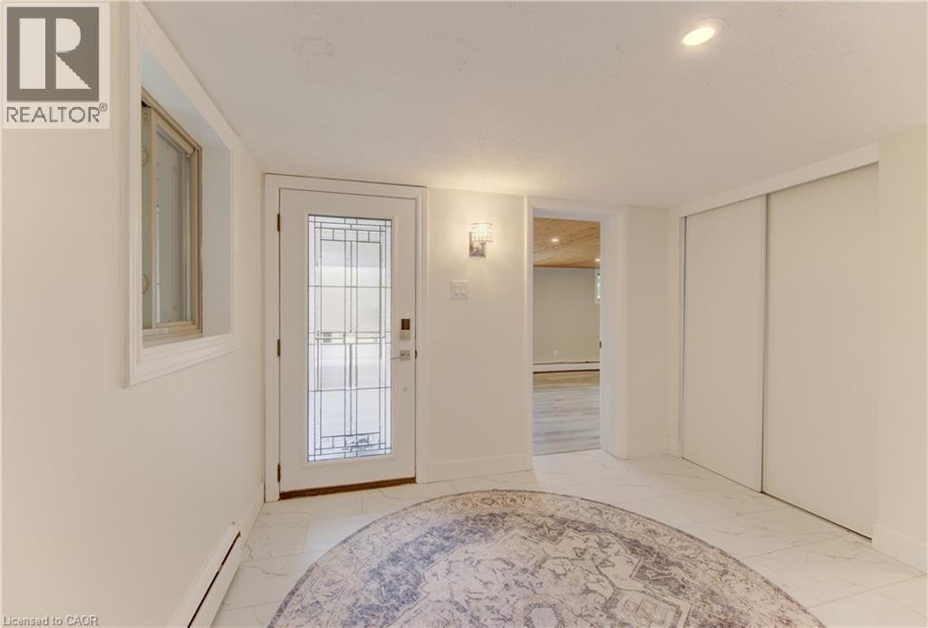 Entryway featuring a white door with decorative glass, a window with white trim, and white walls - 400 Manchester Road, Kitchener, ON - Indoor Photo Showing Other Room