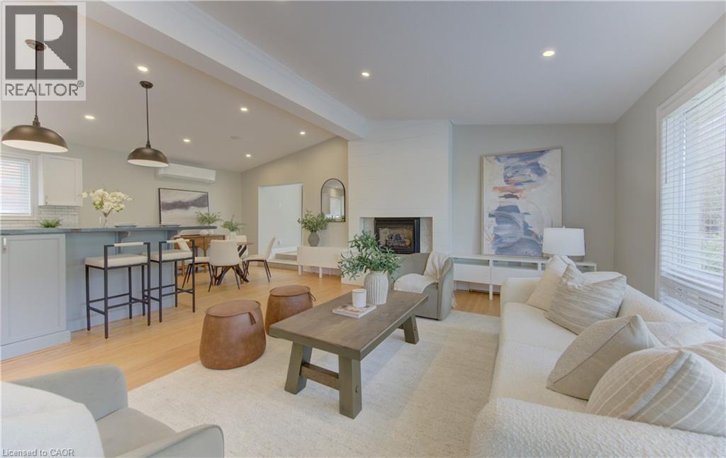 Spacious open concept living area featuring a fireplace, hardwood floors, recessed lighting, and a window with blinds - 400 Manchester Road, Kitchener, ON - Indoor Photo Showing Living Room