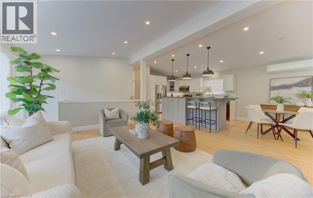 This living space features light wood flooring, recessed lighting, and a kitchen island with pendant lights - 400 Manchester Road, Kitchener, ON - Indoor Photo Showing Living Room