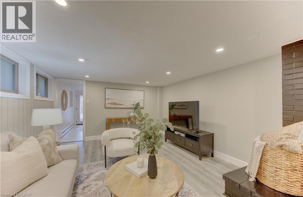 Living area featuring recessed lighting, light-colored walls, a brick fireplace, and light-toned flooring - 400 Manchester Road, Kitchener, ON - Indoor Photo Showing Other Room
