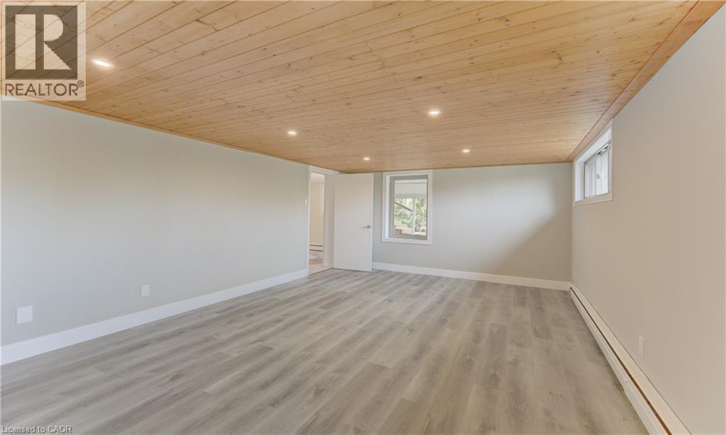 Spacious room featuring light-colored walls, light wood-style flooring, and a natural wood plank ceiling with recessed lighting - 400 Manchester Road, Kitchener, ON - Indoor Photo Showing Other Room