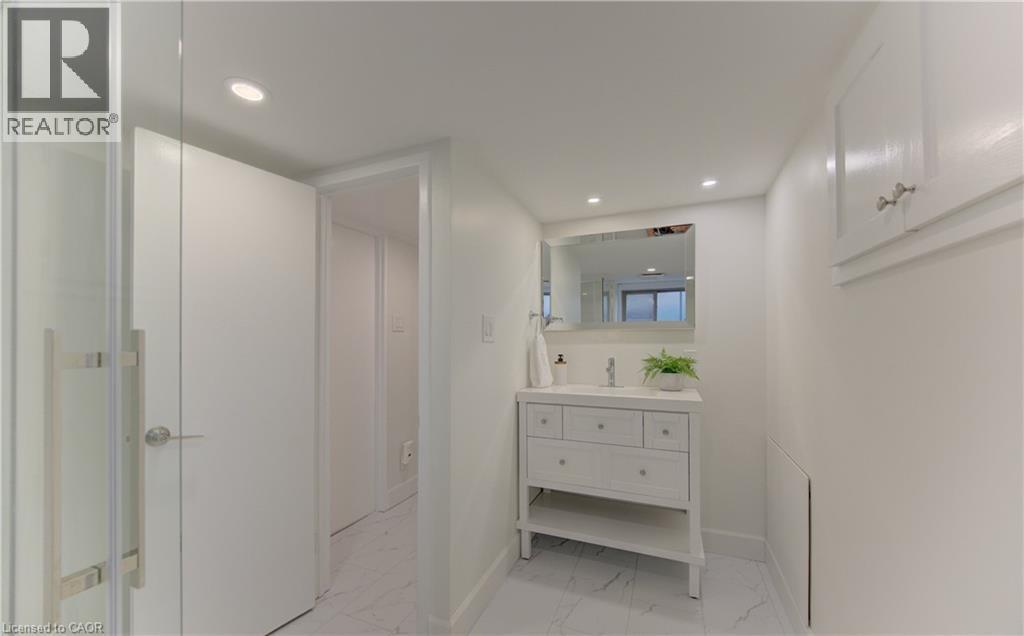 Bathroom featuring a white vanity with drawers and an open shelf, a wall-mounted mirror, and recessed lighting - 400 Manchester Road, Kitchener, ON - Indoor Photo Showing Bathroom