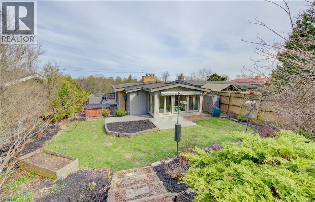The property features an extensive yard with a lawn, a patio, and a hot tub - 400 Manchester Road, Kitchener, ON - Outdoor