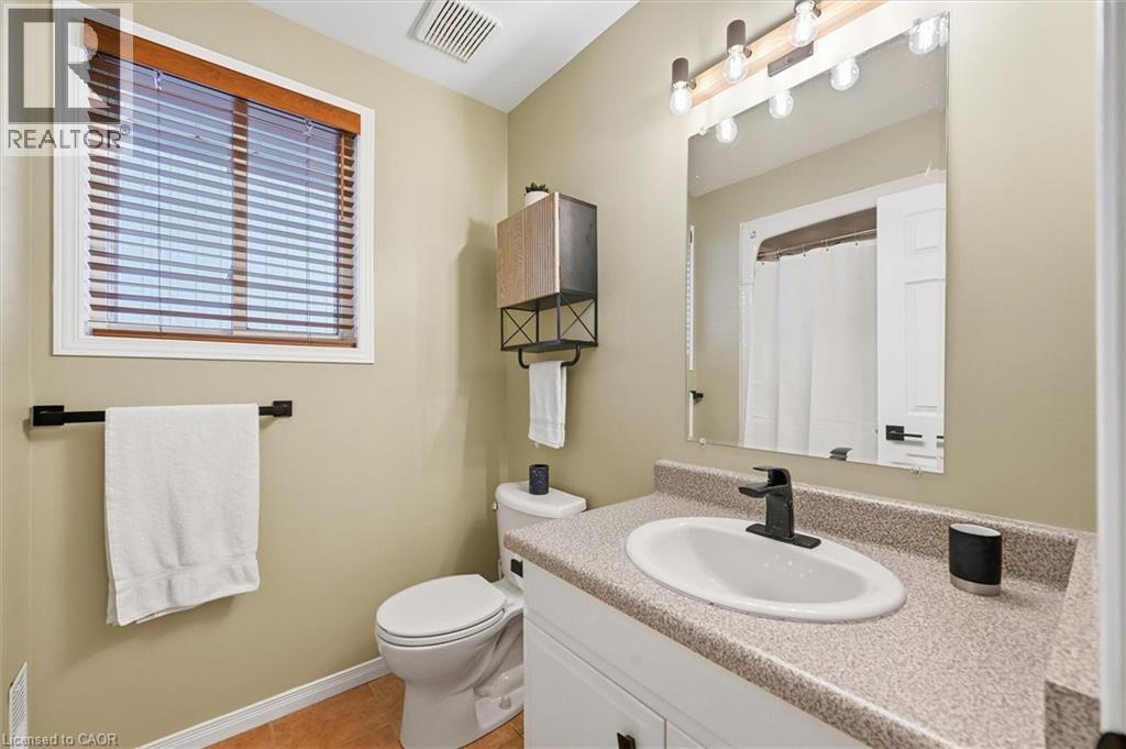 Bathroom with vanity, a shower with shower curtain, and light tile patterned floors - 21 Arden Avenue, Hamilton, ON