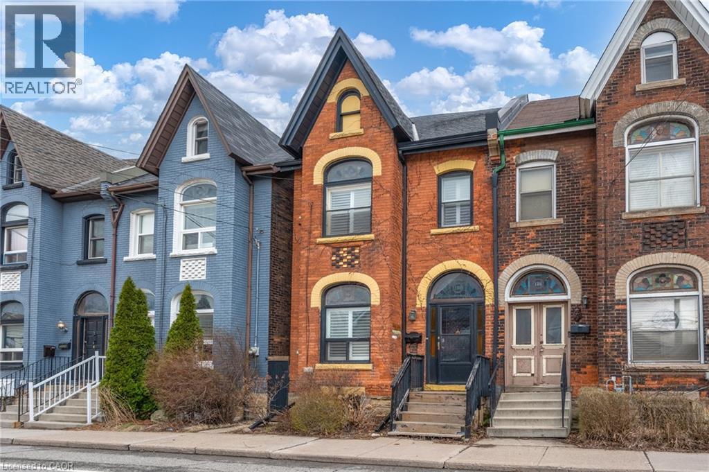 The property features a brick exterior with arched windows and a prominent gabled roofline - 198 Bay Street N, Hamilton, ON - Outdoor With Facade