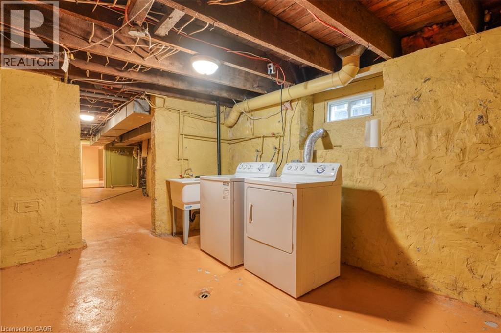 The property includes a dedicated laundry area with a washer, dryer, and utility sink - 198 Bay Street N, Hamilton, ON - Indoor Photo Showing Laundry Room