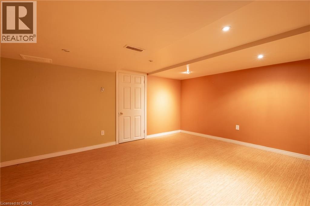 This versatile space features light-colored flooring, recessed lighting, and a neutral wall color with a contrasting accent wall, creating a bright and inviting atmosphere - 198 Bay Street N, Hamilton, ON - Indoor Photo Showing Other Room