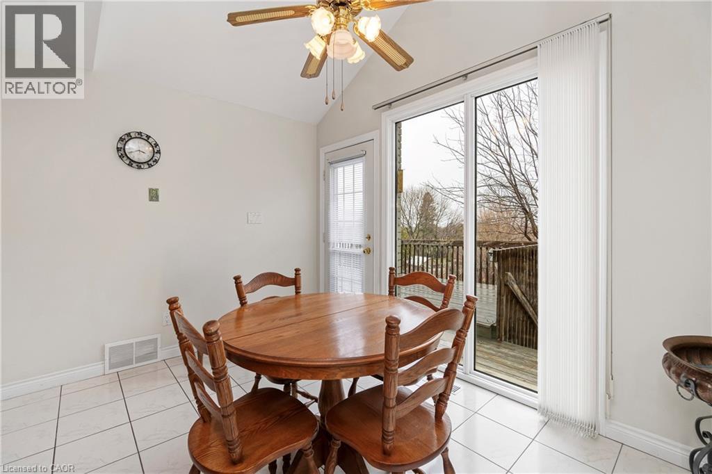 This space features tiled flooring, a ceiling fan with integrated lighting, and a sliding glass door with vertical blinds that opens to a deck area - 36 Buckingham Drive, Hamilton, ON - Indoor Photo Showing Dining Room