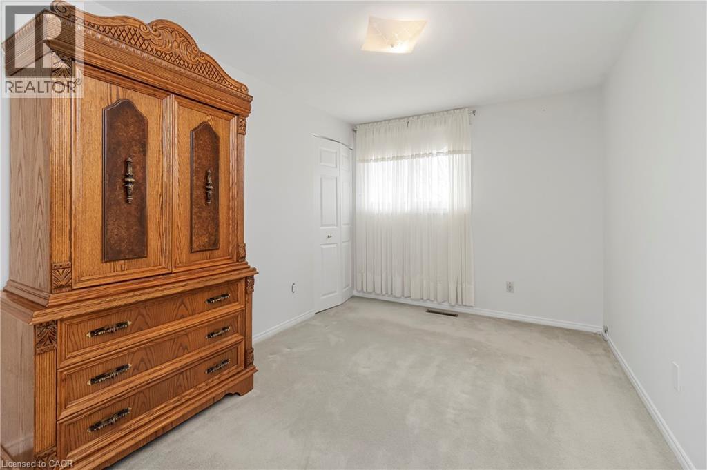 Bedroom featuring light-colored carpeting, a window with sheer curtains, and a ceiling light fixture - 36 Buckingham Drive, Hamilton, ON - Indoor Photo Showing Other Room