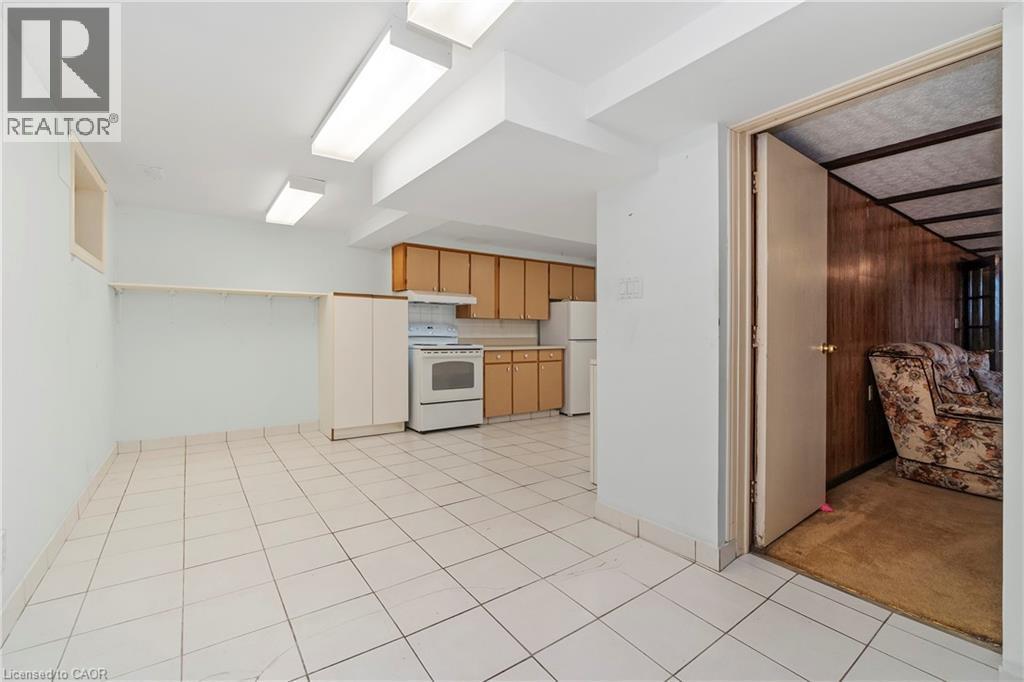 This property features a kitchen area with wood cabinetry, a white stove, and a white refrigerator - 36 Buckingham Drive, Hamilton, ON - Indoor Photo Showing Kitchen