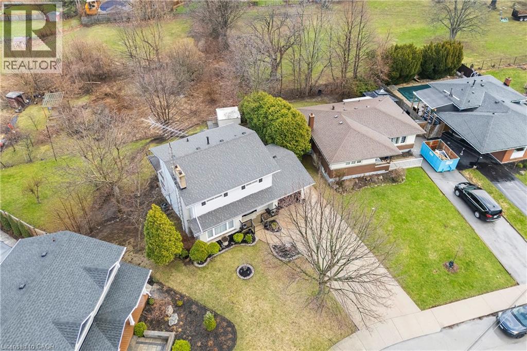 This property features a spacious front yard with a paved driveway and mature trees - 36 Buckingham Drive, Hamilton, ON - Outdoor With View
