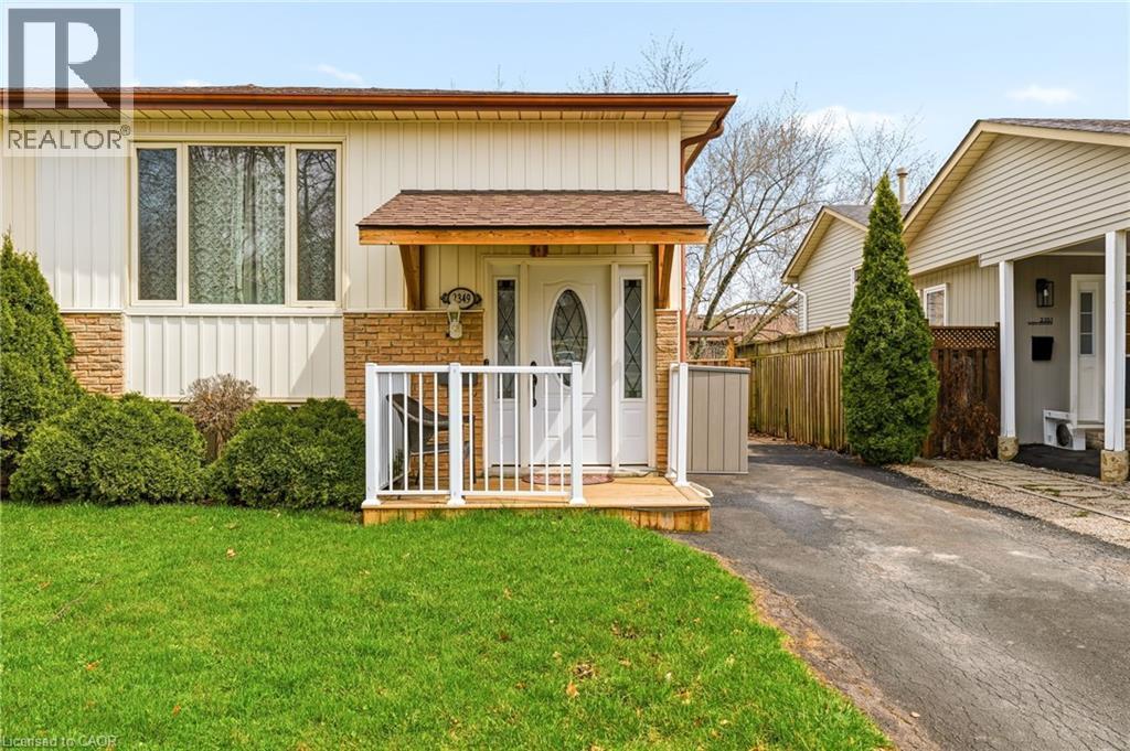 The property features a well-maintained lawn, a paved driveway, and established landscaping including hedges and evergreen trees - 2349 Middlesmoor Crescent, Burlington, ON - Outdoor