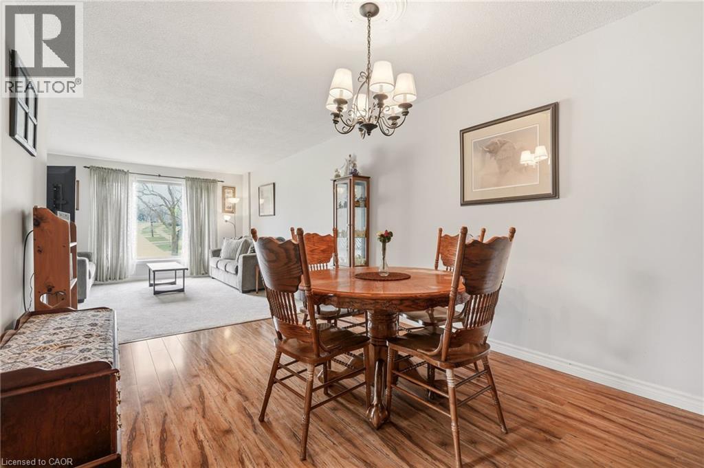 The property features hardwood flooring in the dining area, which includes a chandelier - 2349 Middlesmoor Crescent, Burlington, ON - Indoor Photo Showing Dining Room