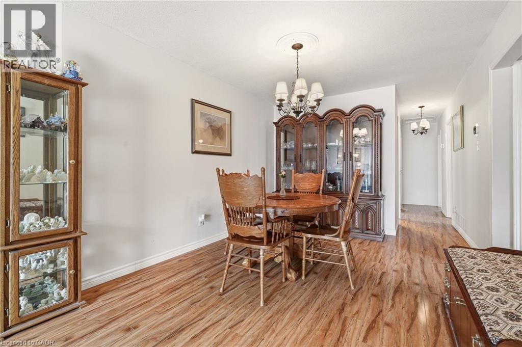 The dining area features light-toned walls, wood-style flooring, and a chandelier with a decorative ceiling medallion - 2349 Middlesmoor Crescent, Burlington, ON - Indoor Photo Showing Dining Room