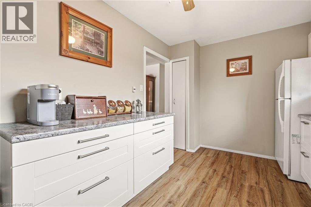 Kitchen featuring wood-style flooring, white cabinetry with silver-toned hardware, and a white refrigerator - 2349 Middlesmoor Crescent, Burlington, ON - Indoor Photo Showing Kitchen