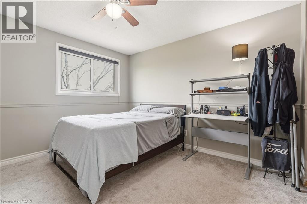 This room features a window providing natural light, a ceiling fan, and carpeted flooring - 2349 Middlesmoor Crescent, Burlington, ON - Indoor Photo Showing Bedroom