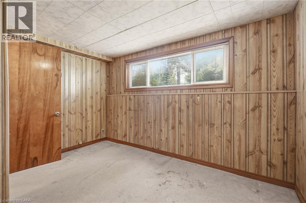 This room features wood paneling, a drop ceiling, and carpeted flooring - 2349 Middlesmoor Crescent, Burlington, ON - Indoor Photo Showing Other Room