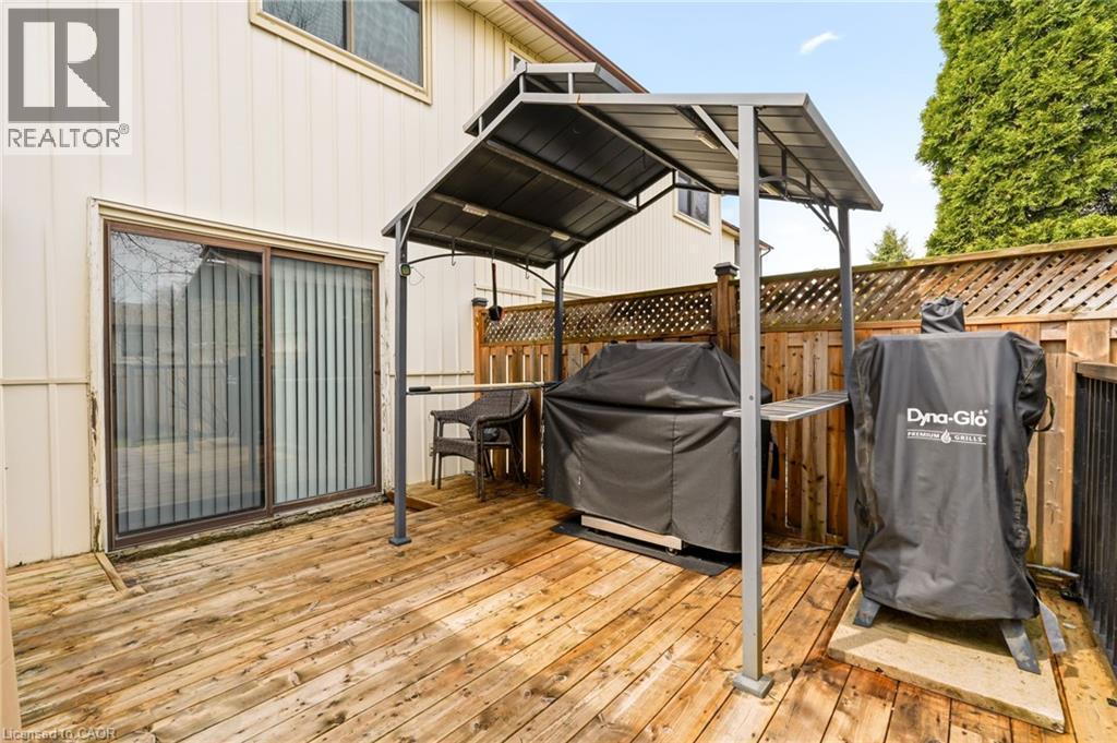 The property features a wooden deck with a privacy fence and a sliding glass door providing outdoor access - 2349 Middlesmoor Crescent, Burlington, ON - Outdoor With Deck Patio Veranda With Exterior