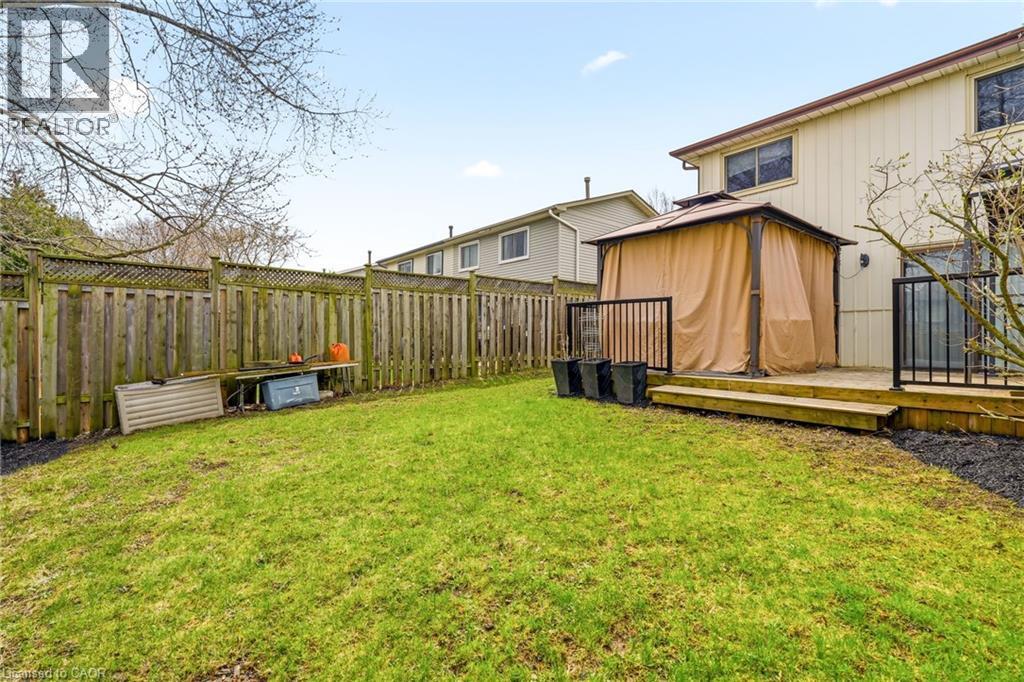 The property features an extensive fenced backyard with a well-maintained lawn and a wooden deck - 2349 Middlesmoor Crescent, Burlington, ON - Outdoor