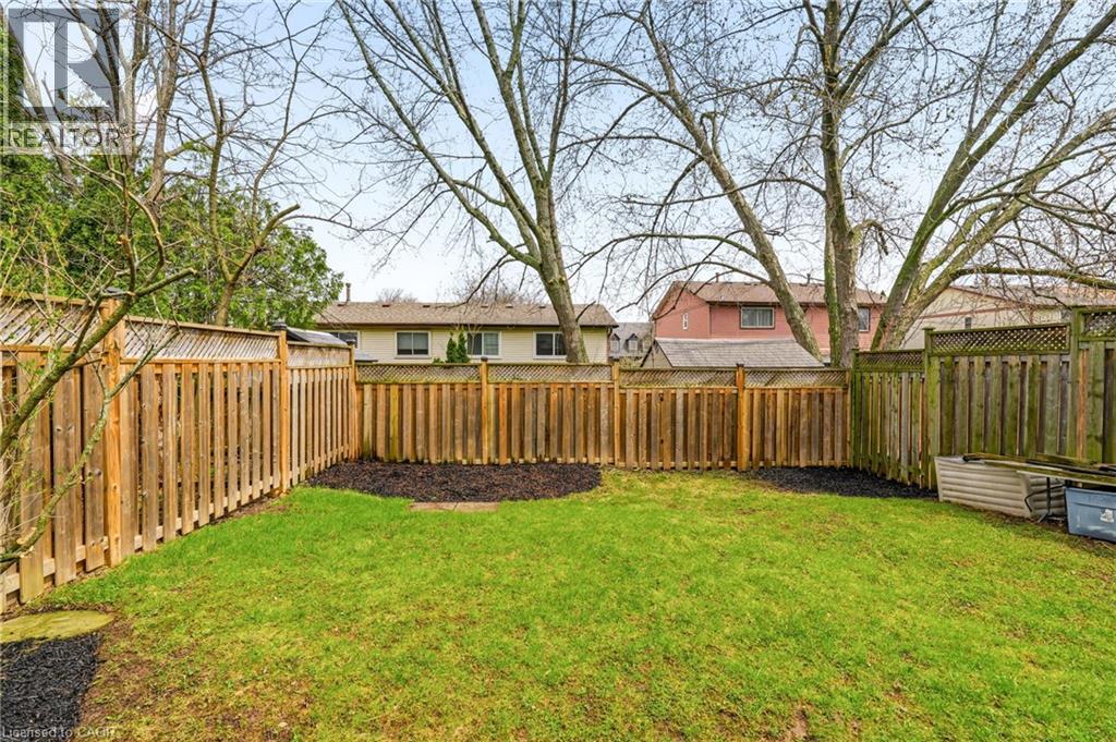 The property features an outdoor area with a well-maintained lawn, surrounded by a wooden fence - 2349 Middlesmoor Crescent, Burlington, ON - Outdoor