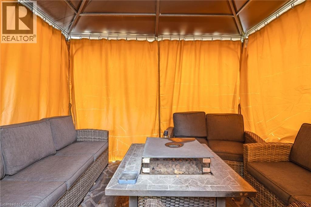 The property features a gazebo with yellow privacy curtains, providing an inviting outdoor living space - 2349 Middlesmoor Crescent, Burlington, ON - Indoor