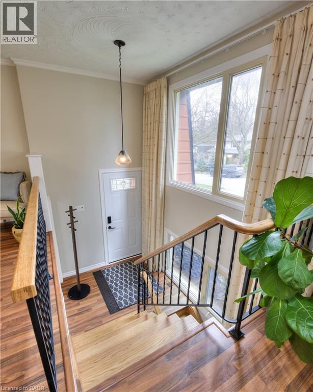 The property features a staircase with wood treads and banisters, wrought iron spindles, and views of the entryway - 42 Culpepper Drive, Waterloo, ON - Indoor Photo Showing Other Room