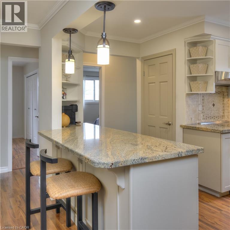 Kitchen featuring a granite island countertop, pendant lighting, and hardwood flooring - 42 Culpepper Drive, Waterloo, ON - Indoor Photo Showing Kitchen
