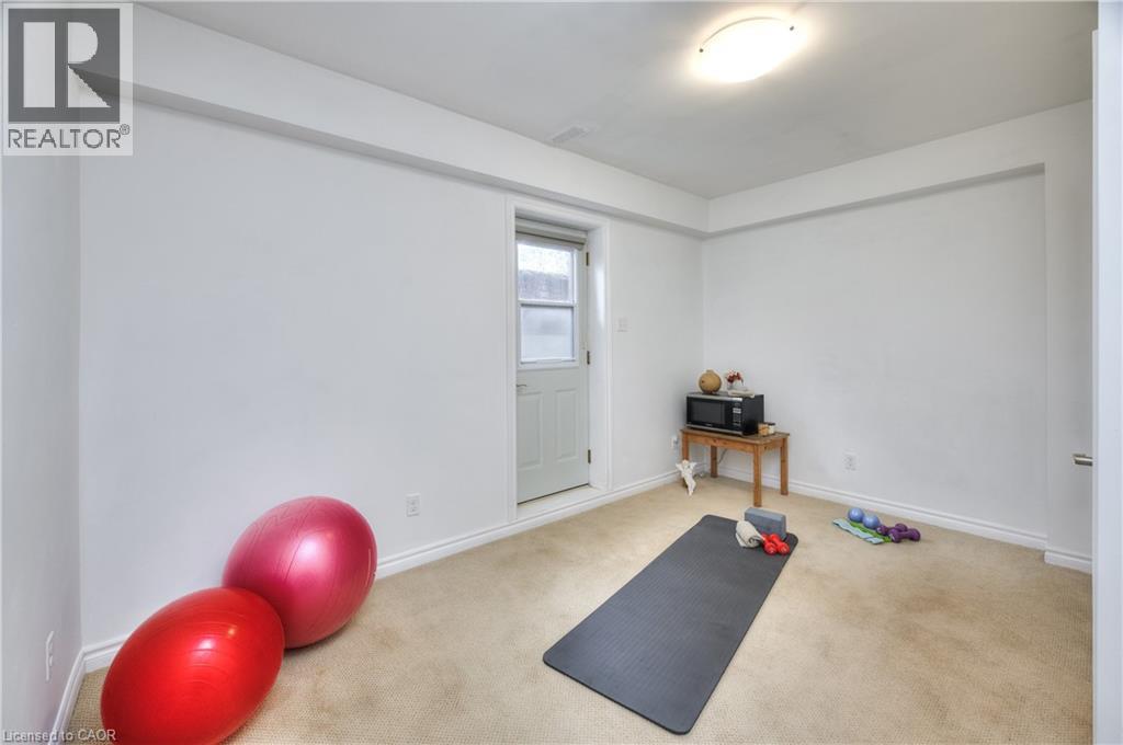 Versatile room with light-colored carpeting, white walls, and a white door with a glass pane - 42 Culpepper Drive, Waterloo, ON - Indoor